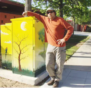 Sandro Gia Artist Standing by Mural Yellow Trees